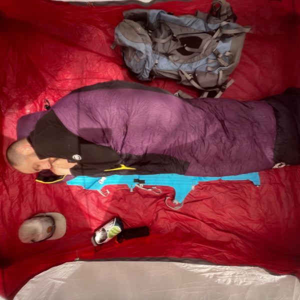 Man sleeping in a tent in a sleeping pad while sleeping comfortably on an inflatable sleeping pad