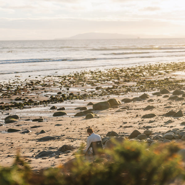 Man sitting in a casual chair on the beach at sunset