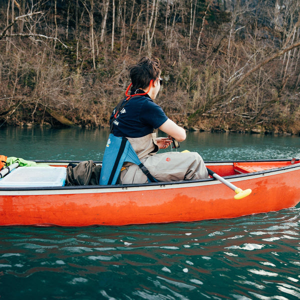 Man fishing in a red canoe while sitting in a casual comfortable chair