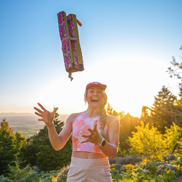 Rachel Pohl throwing the rolled up crazy creek chair into the air