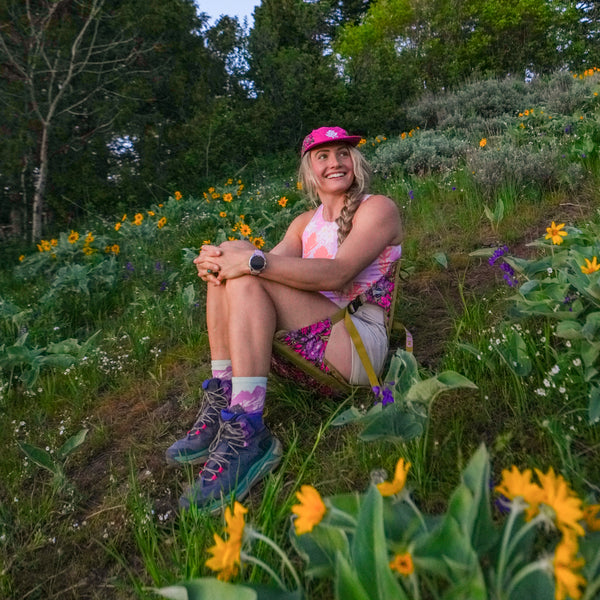 Rachel Pohl comfortably sitting int he floral crazy creek hex chair in a field of wildflowers