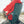 Person sitting on a rock wearing a red jacket sitting in a green crazy creek camping chair