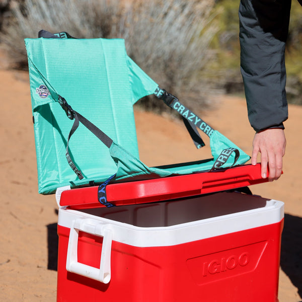Crazy Creek chair strapped on to an ice chest at camp turning it into a tall chair