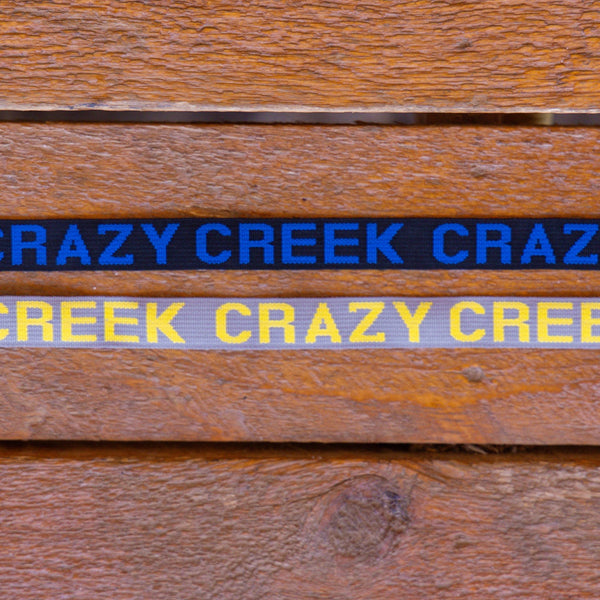 Close up of webbing with the crazy creek name on it in grey and yellow and black and blue