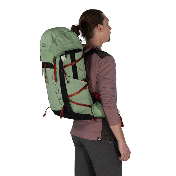 Backpacking man carrying the Osprey and Crazy Creek Collab Backpack on white - 3.4 angle