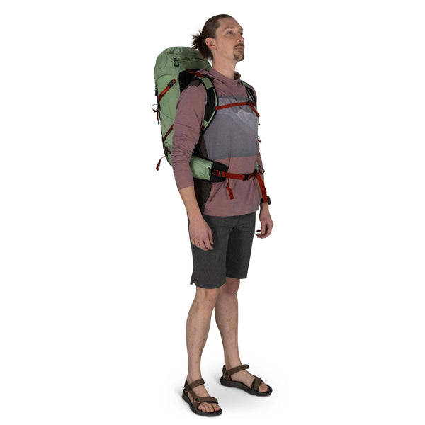 Backpacking man carrying the Osprey and Crazy Creek Collab backpack full body on white