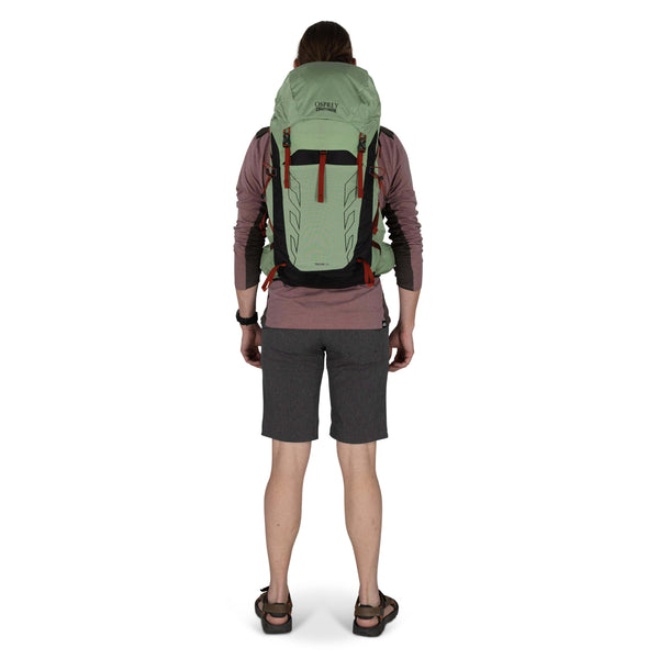 Backpacking man carrying the Osprey and Crazy Creek Collab backpack full body on white - facing back